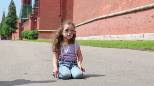 Niña cerca de gran pared roja — Vídeo de stock