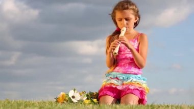 Küçük kız oturur ve flüt çalış
