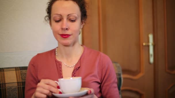 Glimlachend jonge vrouw drinkt koffie — Stockvideo