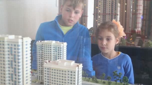 Kids look at layout of buildings — Stock Video