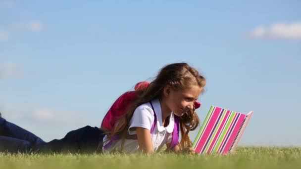 Niña mira el libro — Vídeo de stock