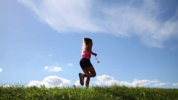Kleines Mädchen läuft auf grünem Gras — Stockvideo