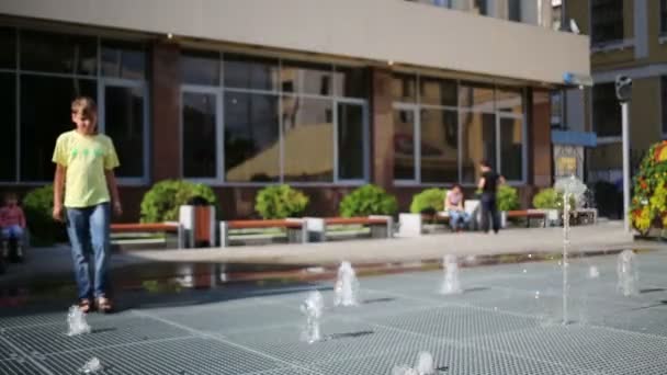 Boy on grid with many fountains — Stock Video