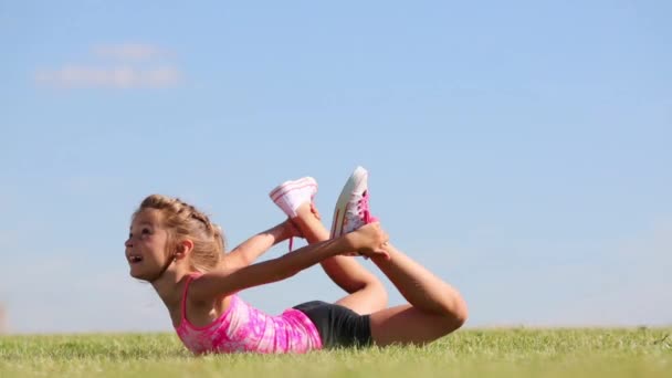 Niña en pantalones cortos hace ejercicio — Vídeos de Stock