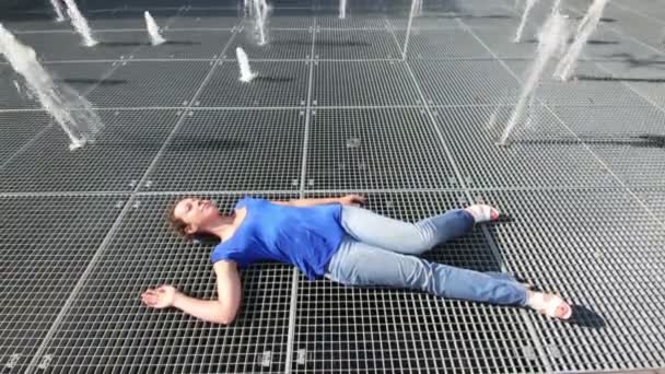 Vrouw ligt op de grid voor fontein — Stockvideo