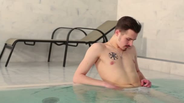 Homem tem descanso na piscina — Vídeo de Stock
