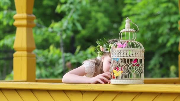 Menina em grinalda brinca com gaiola — Vídeo de Stock