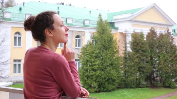 Спина жінки, що стоїть на балконі — стокове відео