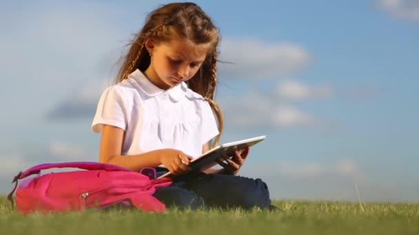Little girl with tablet pc on field — Stock Video