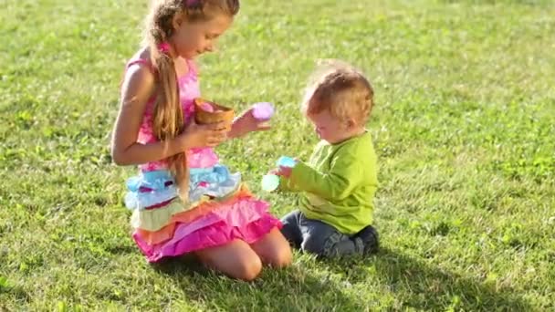 Los niños juegan con huevos de colores — Vídeos de Stock