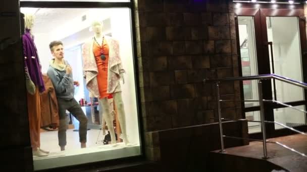 Muž tancuje v prezentovat obchodu s oděvy