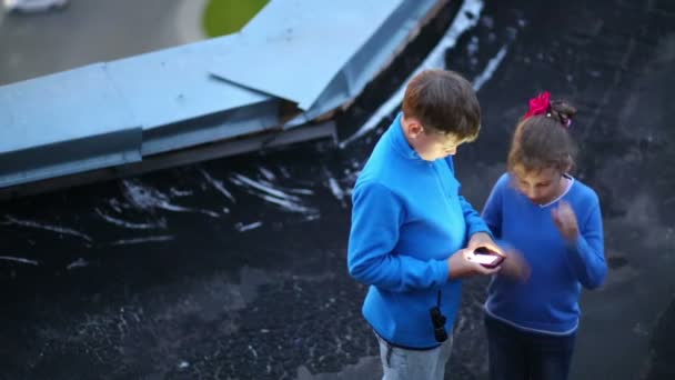 Niña y niño de pie en el techo — Vídeo de stock