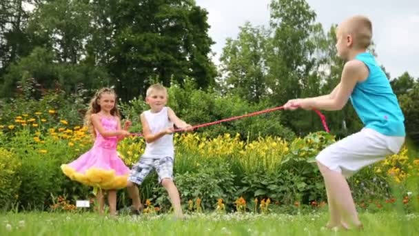 Two boys and girl pull rope — Stock Video