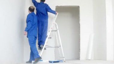 İki işçi duvar spackling hazırlamak 