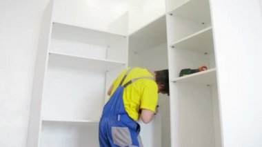 Worker assembles wardrobe 