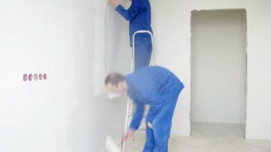 Workers applied plaster on walls 