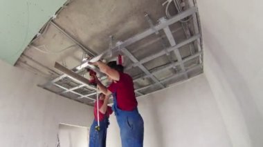 İki işçi tavana asma aparatı monte
