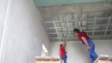 işçiler tavana asma aparatı monte