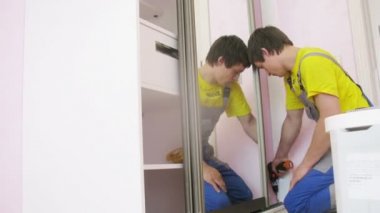 Worker assembles wardrobe 