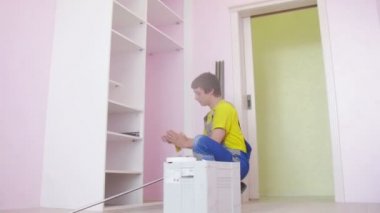 Worker assembles wardrobe 