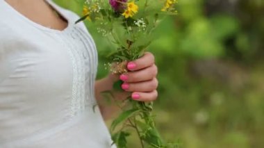 beyaz kır çiçekleri tutan kadın