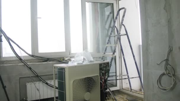Werknemer mounts draden voor airconditioning. — Stockvideo
