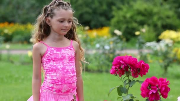 Chica en rosa toca flores rosadas — Vídeo de stock