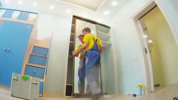 Worker assembles door in closet — Stock video