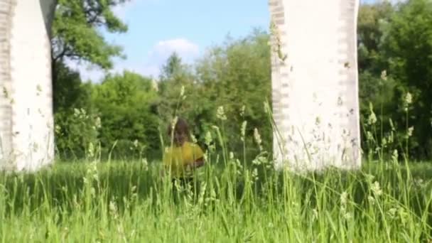 Petit garçon marche dans l'herbe verte — Video