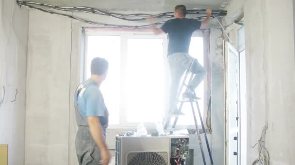 Werknemers mounts draden voor airconditioning — Stockvideo