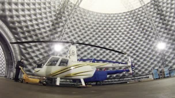 Werknemer verhuist helikopter naar hangar — Stockvideo