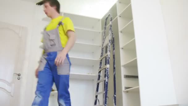 Arbeiter montiert verspiegelten Türschrank — Stockvideo