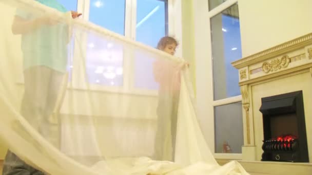 Two children put curtains — Stock Video