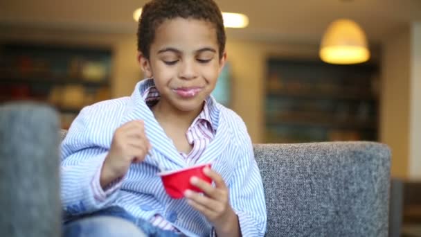 Little curly boy  eating yogurt — Stock Video