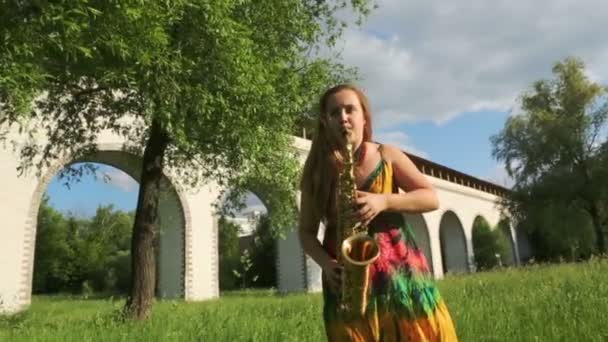 Menina de vestido toca saxofone — Vídeo de Stock