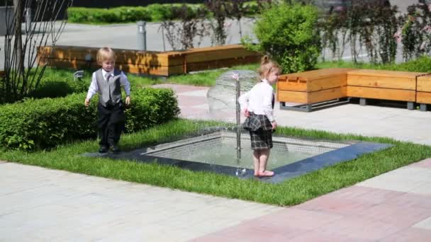 Niño y niña cerca de la fuente — Vídeo de stock