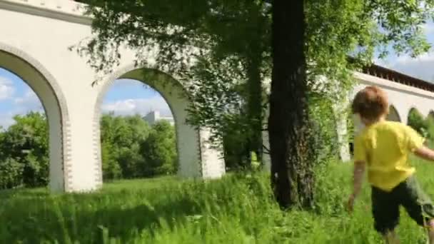 Kleiner Junge läuft auf Gras — Stockvideo