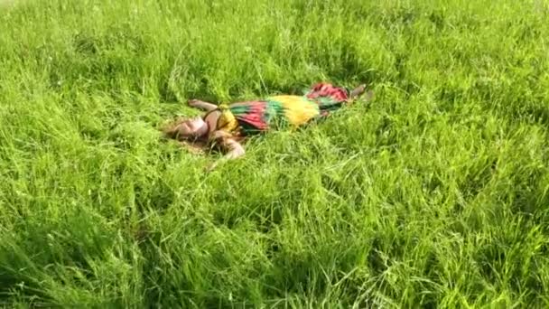 Belle fille en robe repose sur l'herbe 
