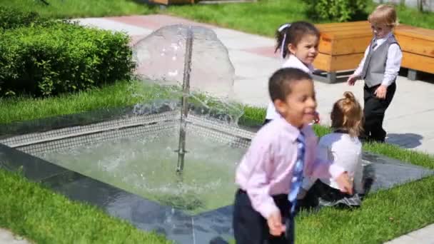 Cuatro niños cerca de la fuente — Vídeo de stock