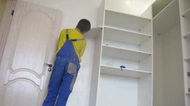 Worker mounts shelves for cupboard — 图库视频影像