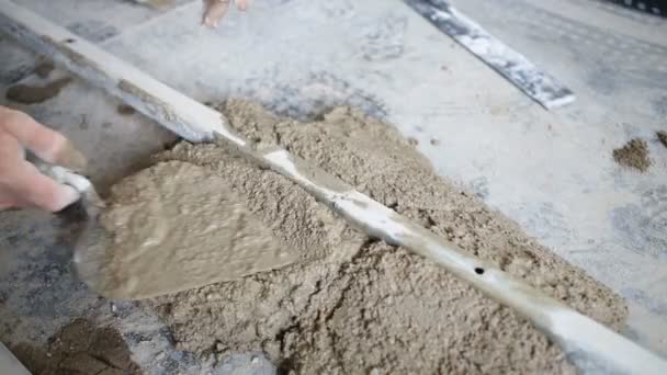 Рука рабочего кладет бетонное решение — стоковое видео