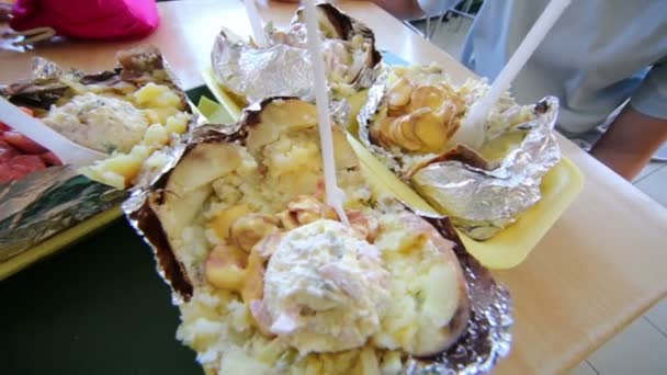 Baked potato with additives on table — Stock Video
