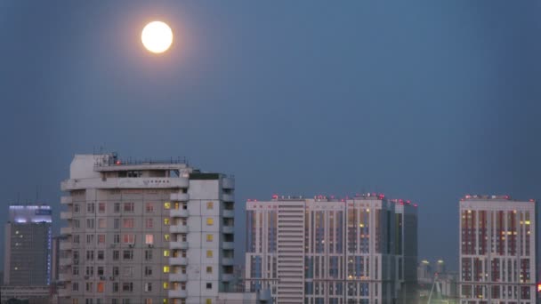 Moon rising over modern city — Stock Video