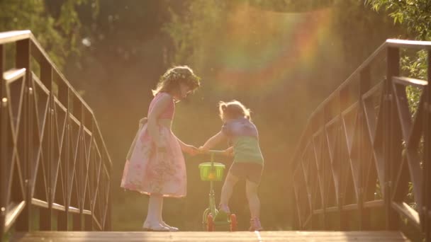 Маленькие красивые девочки играют со скутером — стоковое видео