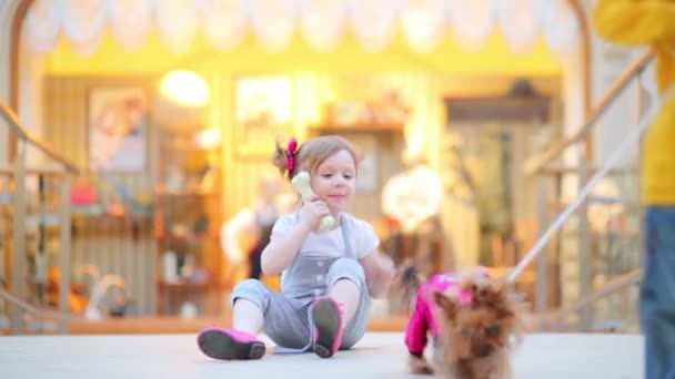 小さな女の子がおもちゃの骨を保持しています。 — ストック動画