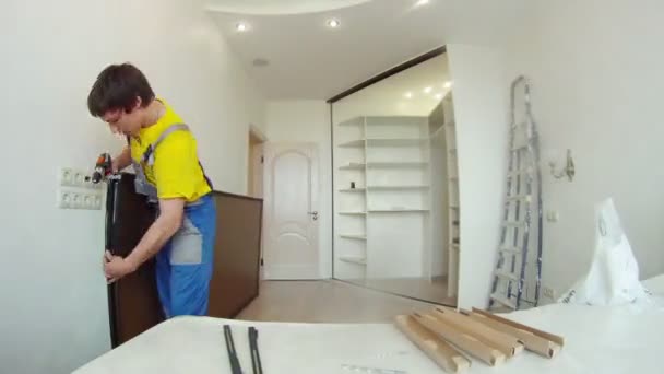 Arbetaren monterar speglad dörr garderob — Stockvideo