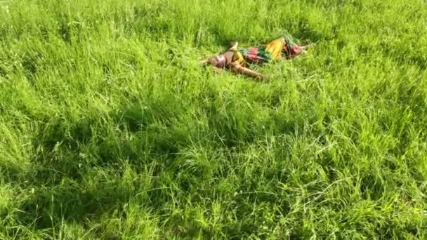 Belle fille en robe repose sur l'herbe 