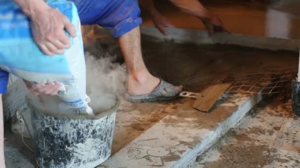 Män att göra avjämningsmassa för golv — Stockvideo