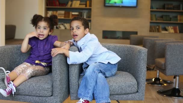 Niño y niña en sillones — Vídeos de Stock