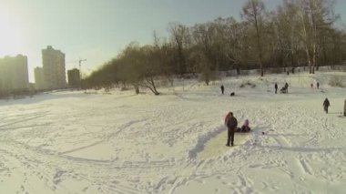 Buzlu su birikintisi üzerinde çocuklu insanlar
